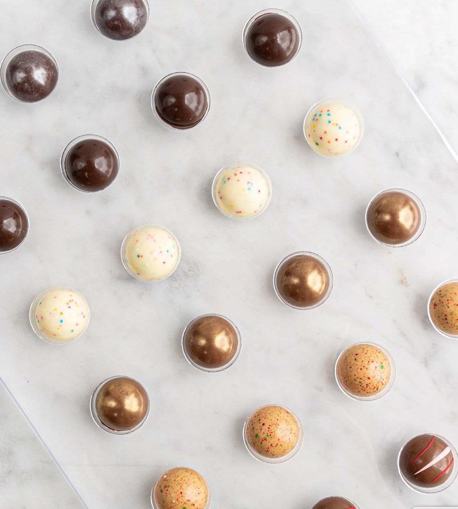 Assorted chocolate truffles on a white surface