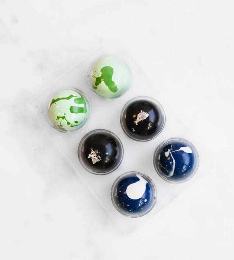 Set of six decorative glass knobs with various designs on a white background