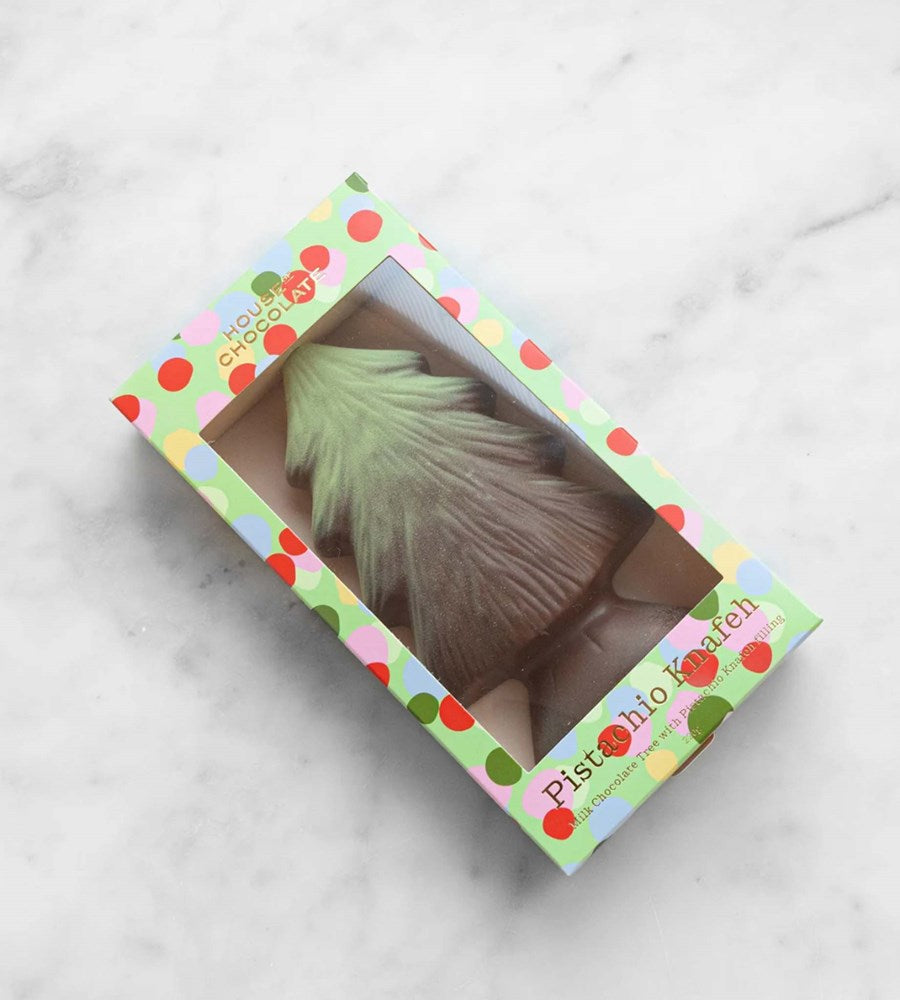 Pistachio-shaped product in a colorful box on a marble surface