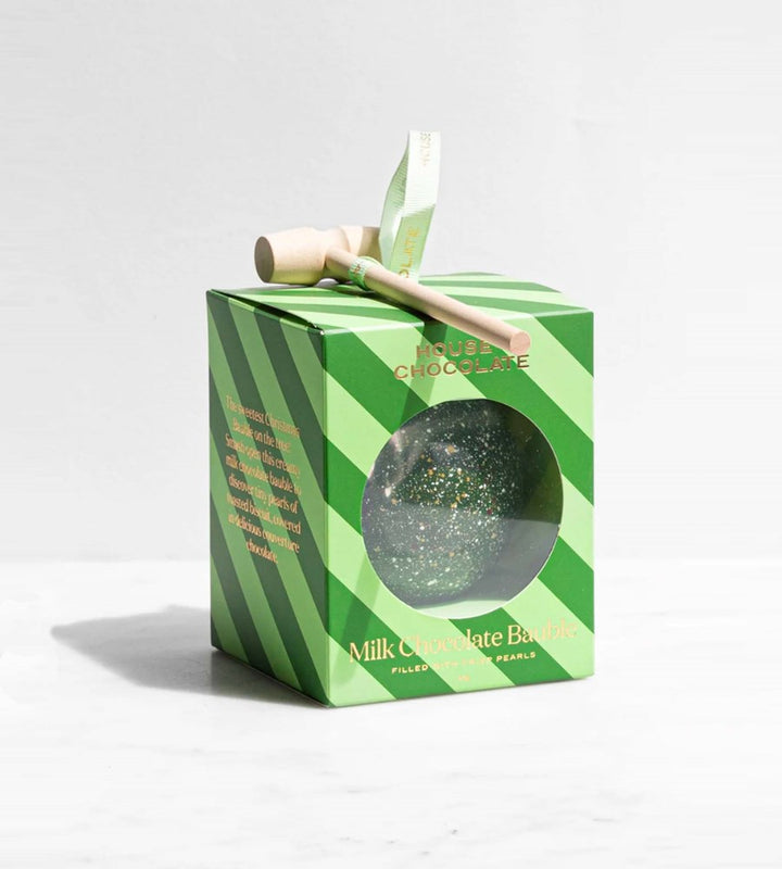 Green striped box with a chocolate bar and hammer on a white background