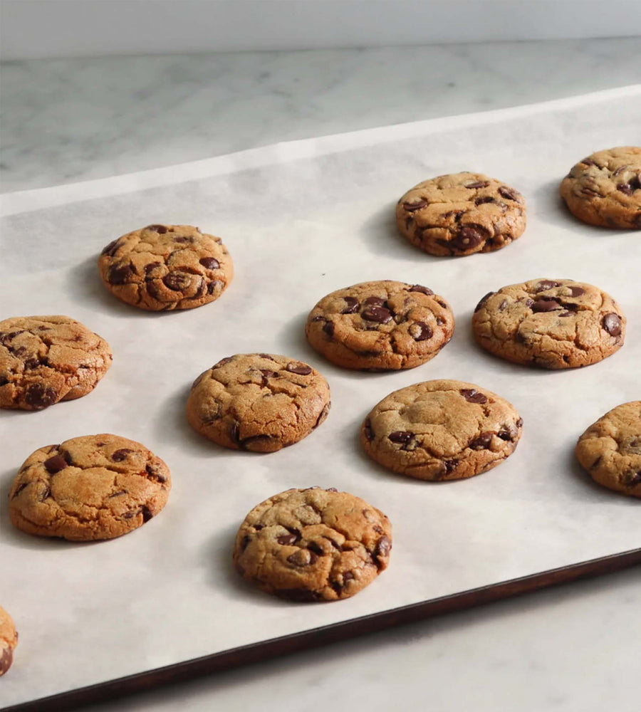 Chocolate chip cookies on a baking tray with parchment paper