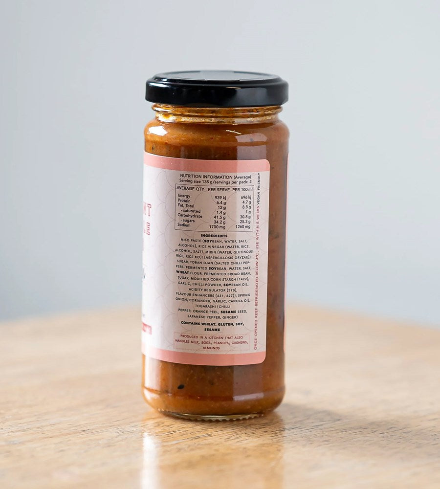 Jar of sauce with a nutrition label on a wooden surface