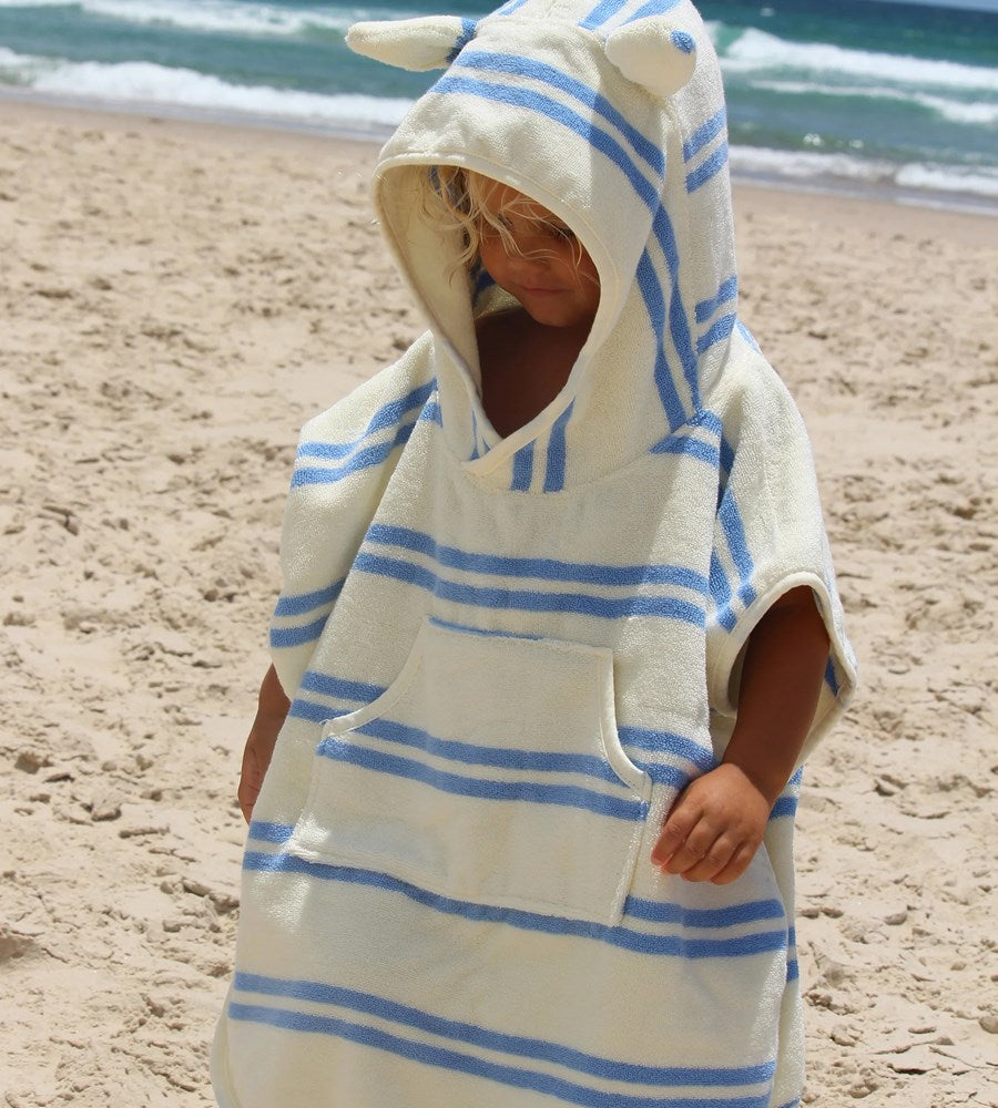 Child wearing a striped towel with animal ears on a beach