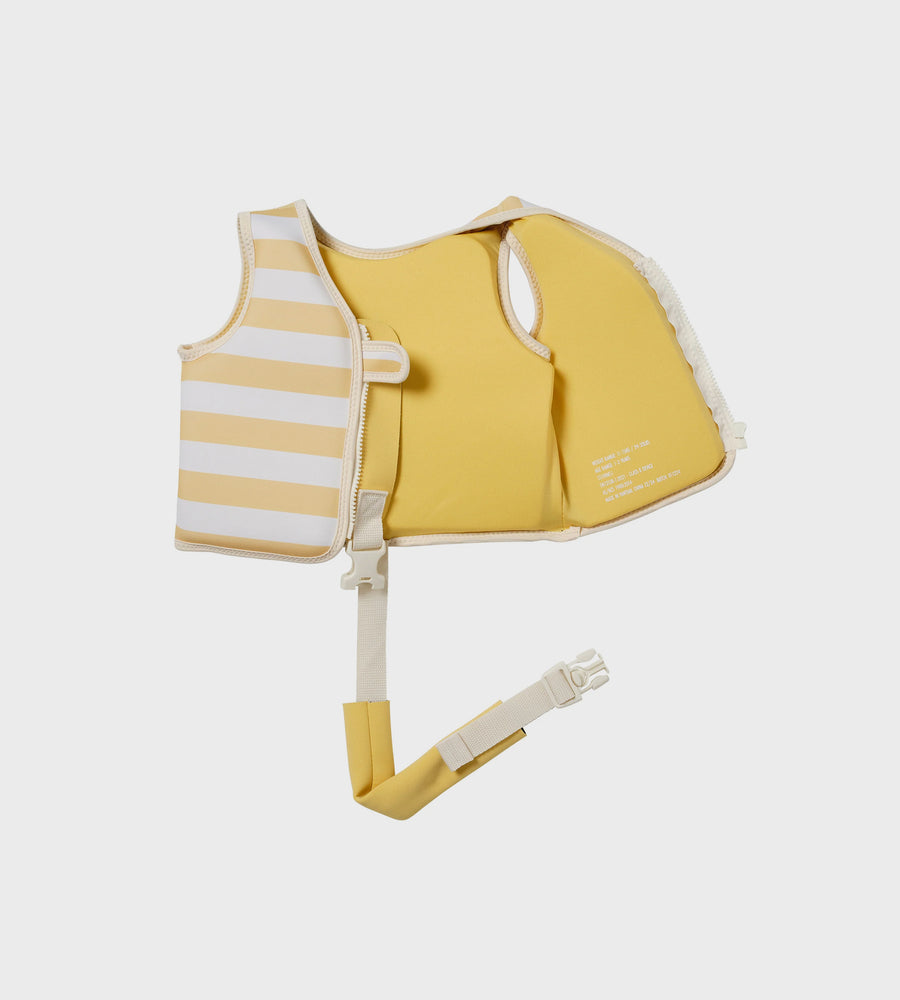 Yellow and white striped baby life jacket on a light beige background