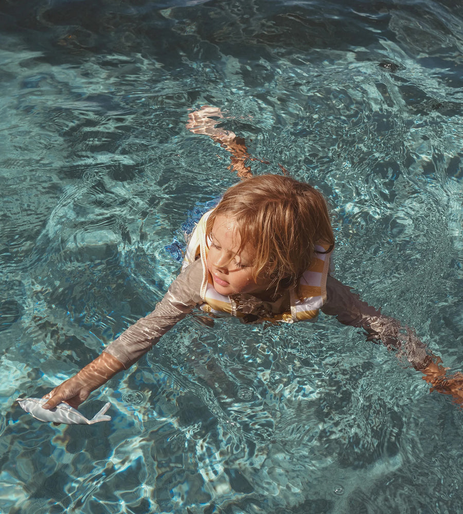 Child swimming in clear blue water