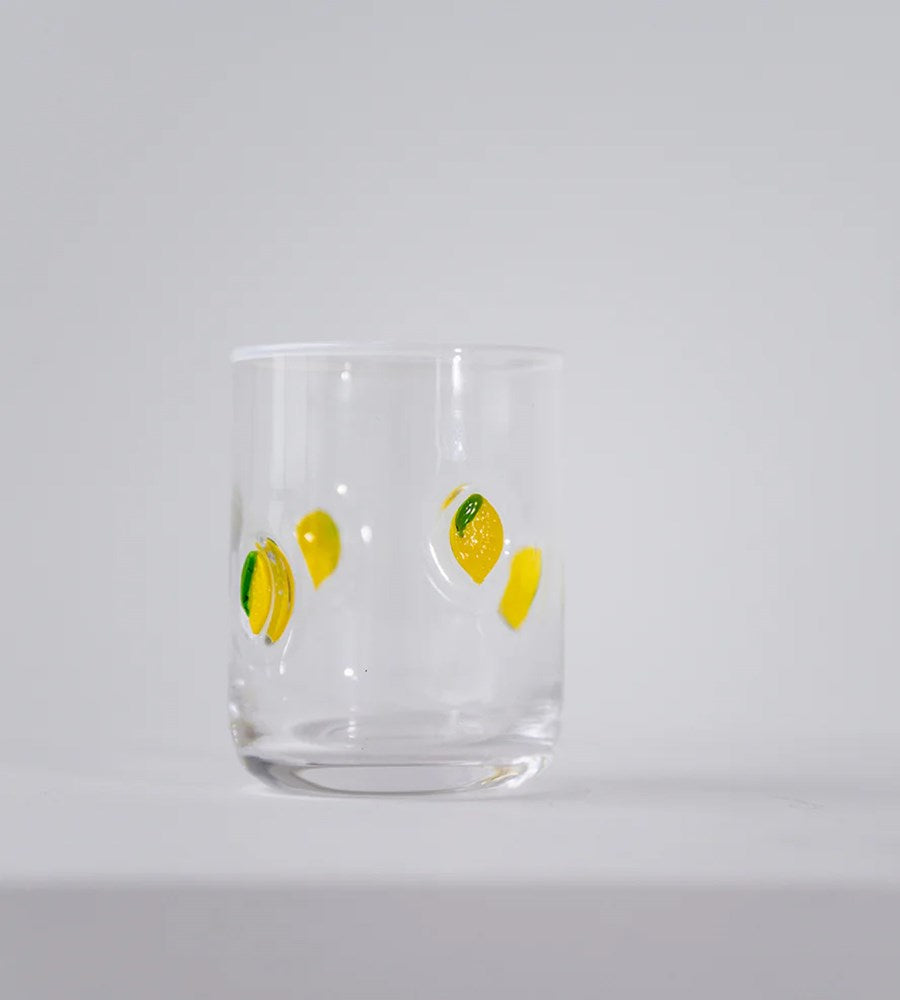 Clear glass with lemon designs on a light gray background
