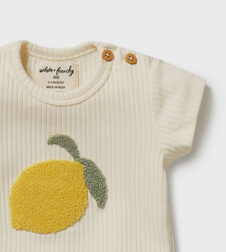 Baby romper with lemon design and 'Wilton & Friends' branding on a white background