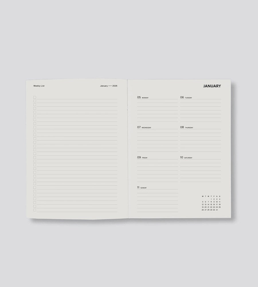 Open planner showing a monthly layout with a calendar on a light gray background