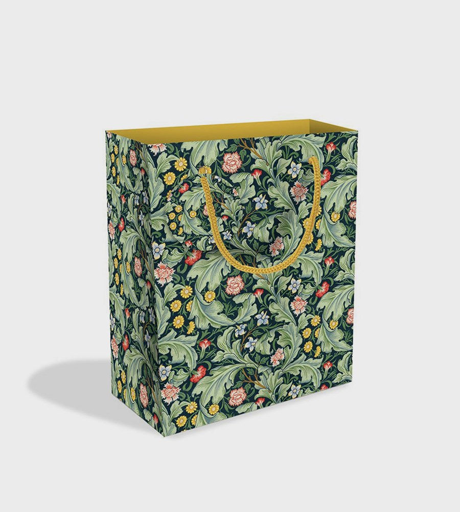 Floral patterned bag with a gold handle on a light gray background