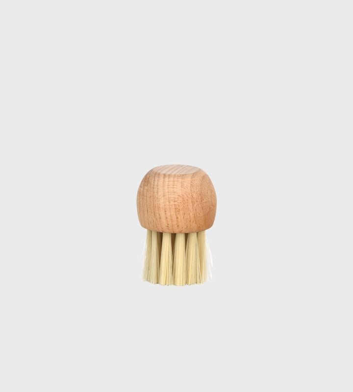 Wooden brush with a round handle on a light gray background