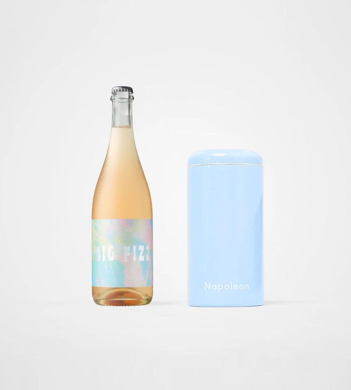 Bottle of wine with a colorful label next to a blue container on a white background