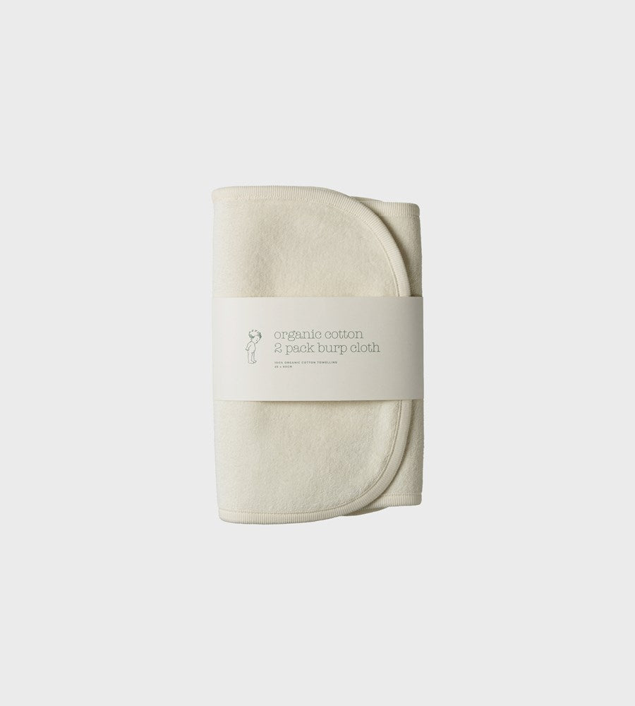 Folded beige burp cloth with a label on a light gray background