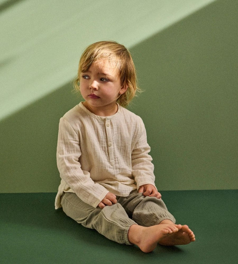 Child sitting on a green floor against a green wall