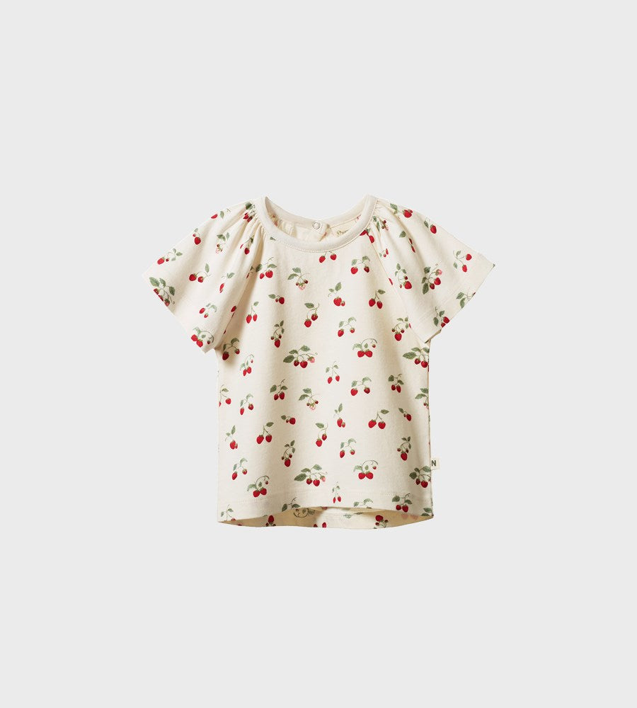 White blouse with cherry pattern on a light gray background