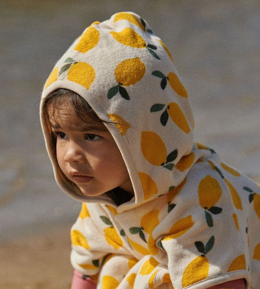 Child wearing a hoodie with lemon pattern outdoors