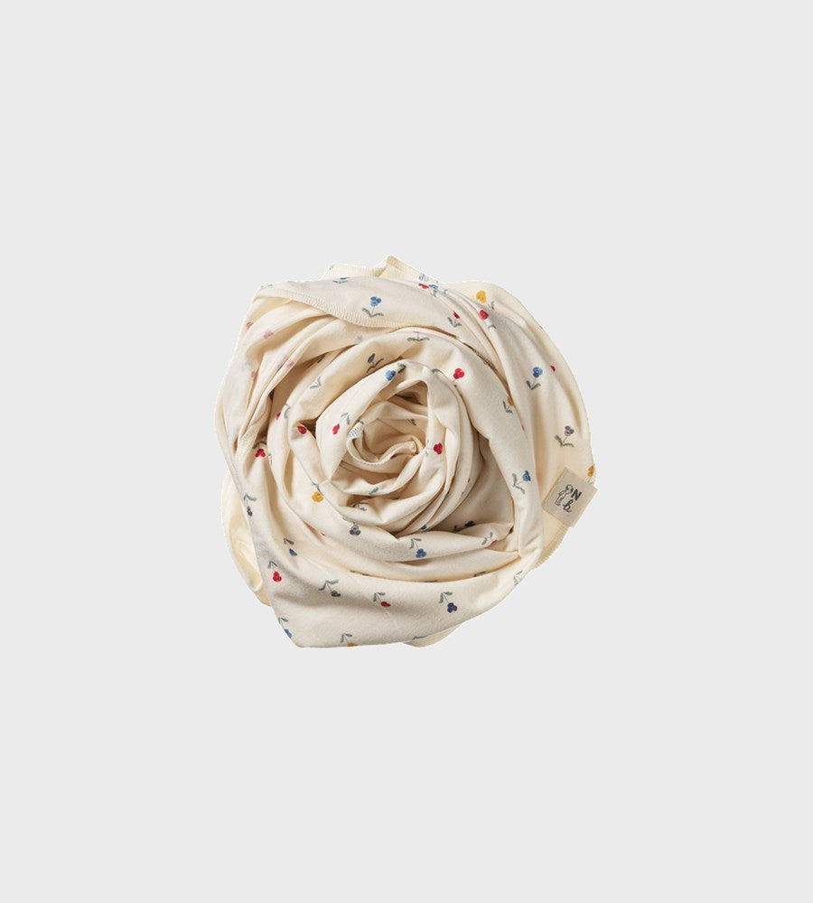 Rolled-up fabric with small colorful patterns on a light gray background