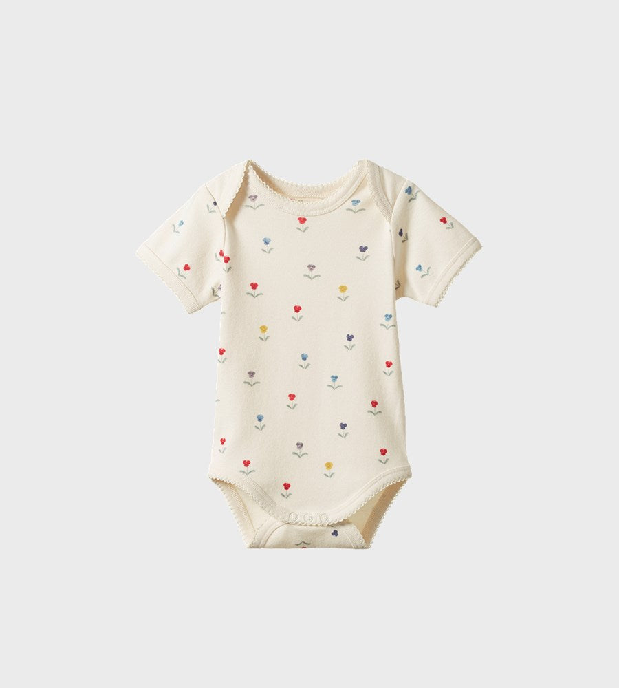 Baby onesie with colorful heart patterns on a white background