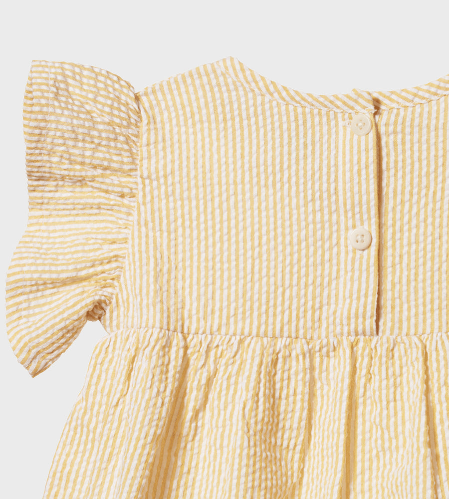 Close-up of a yellow and white striped dress with ruffled sleeves on a light gray background