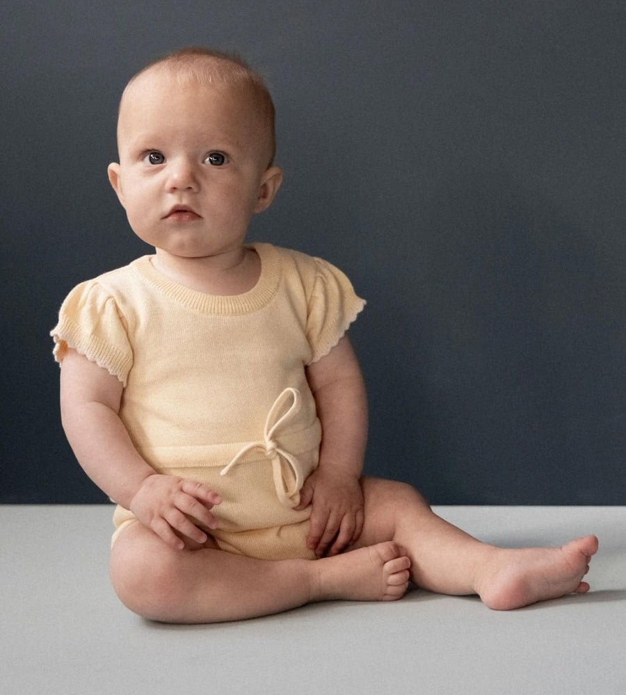 baby is a yellow bodysuit