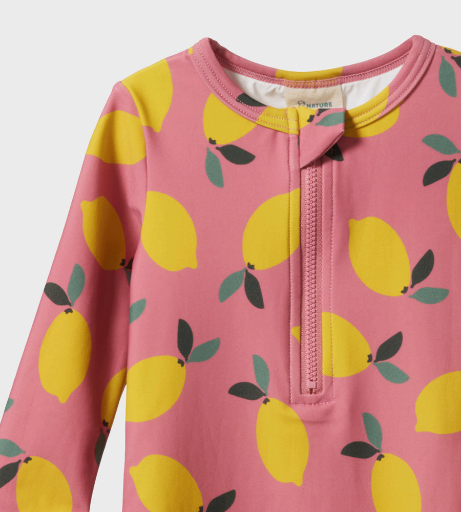 Pink children's garment with lemon pattern on a white background