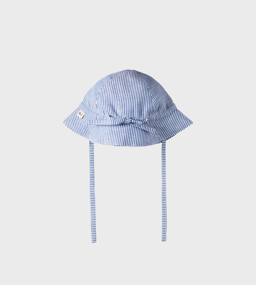 Blue and white striped baby hat with chin straps on a light gray background