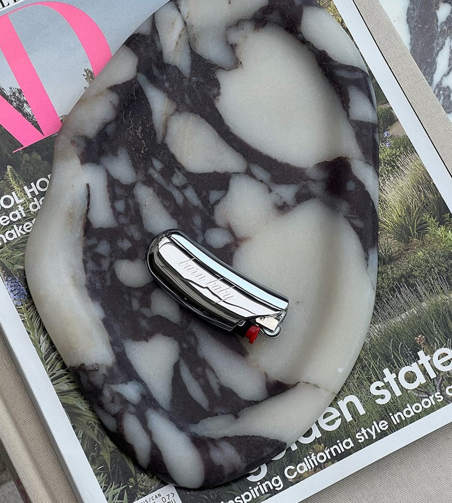 Marble-patterned object with a small metallic item on top, placed on a magazine