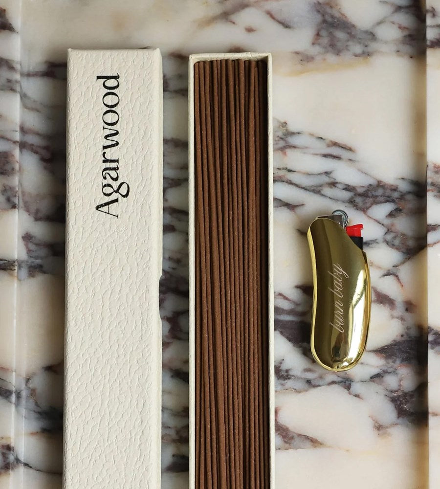 Agarwood product with packaging and lighter on a marble surface