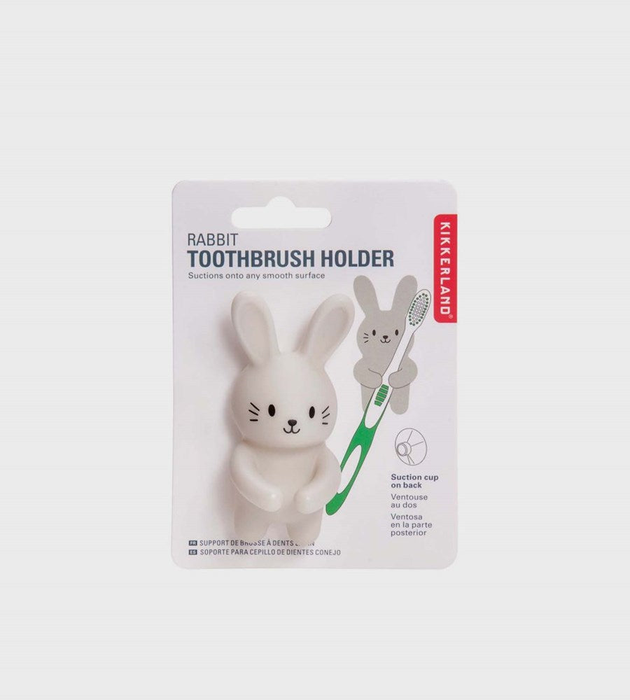 Rabbit-shaped toothbrush holder with a green toothbrush in packaging on a white background