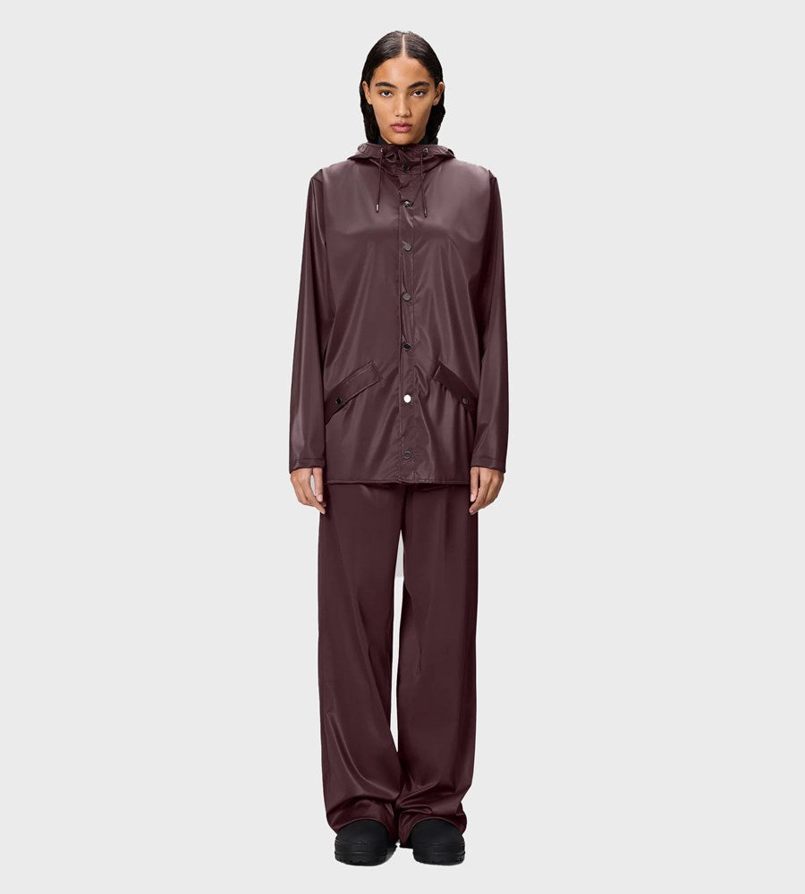 Person wearing a maroon raincoat and pants on a white background