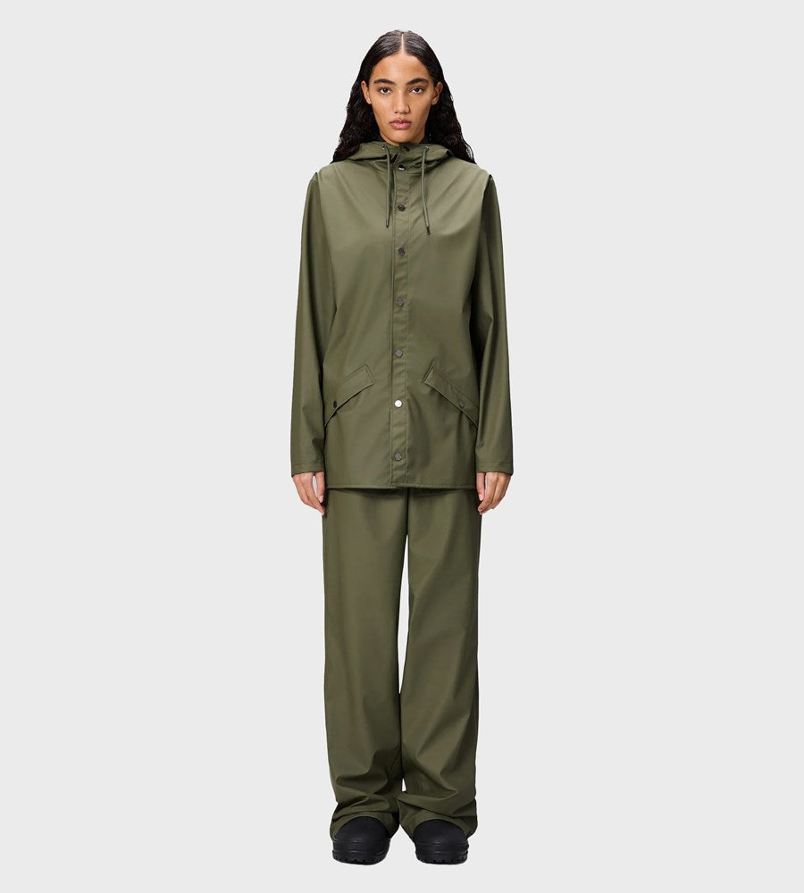 Person wearing a green raincoat and pants on a white background
