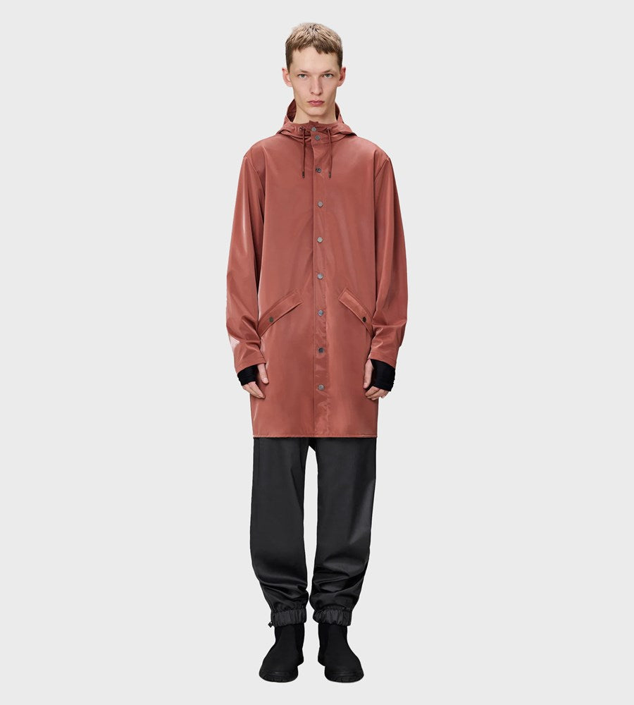 Person wearing a long brown raincoat on a white background