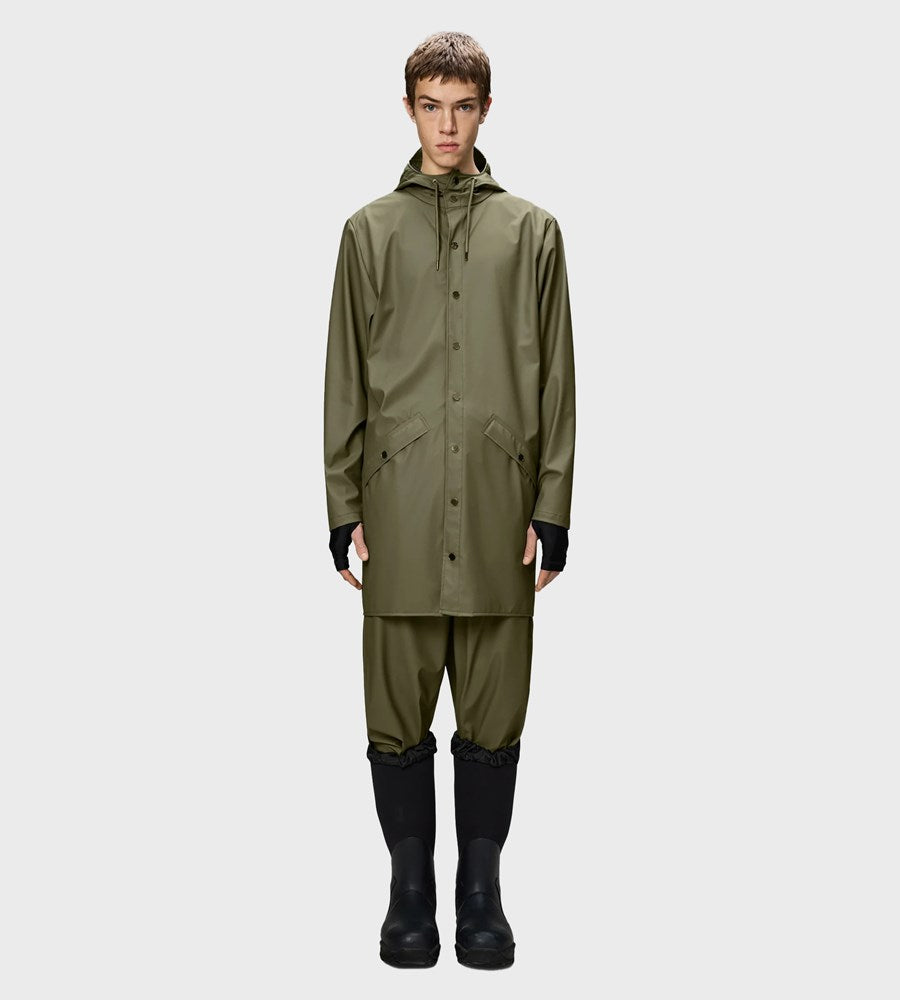 Person wearing a green raincoat and pants with black boots on a white background