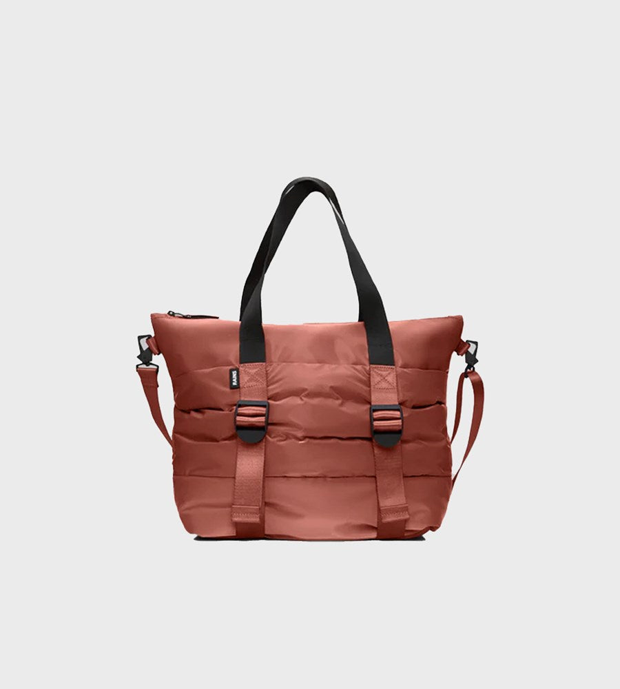 Brown bag with black straps on a light gray background