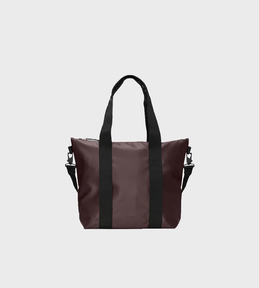 Brown tote bag with black straps on a light gray background