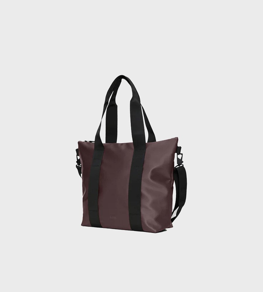 Brown tote bag with black straps on a light gray background