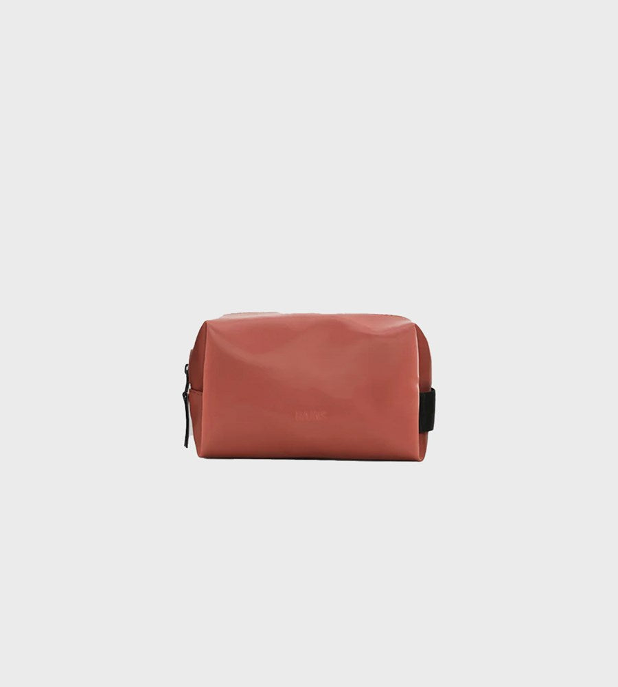 red toiletry bag on a light gray background