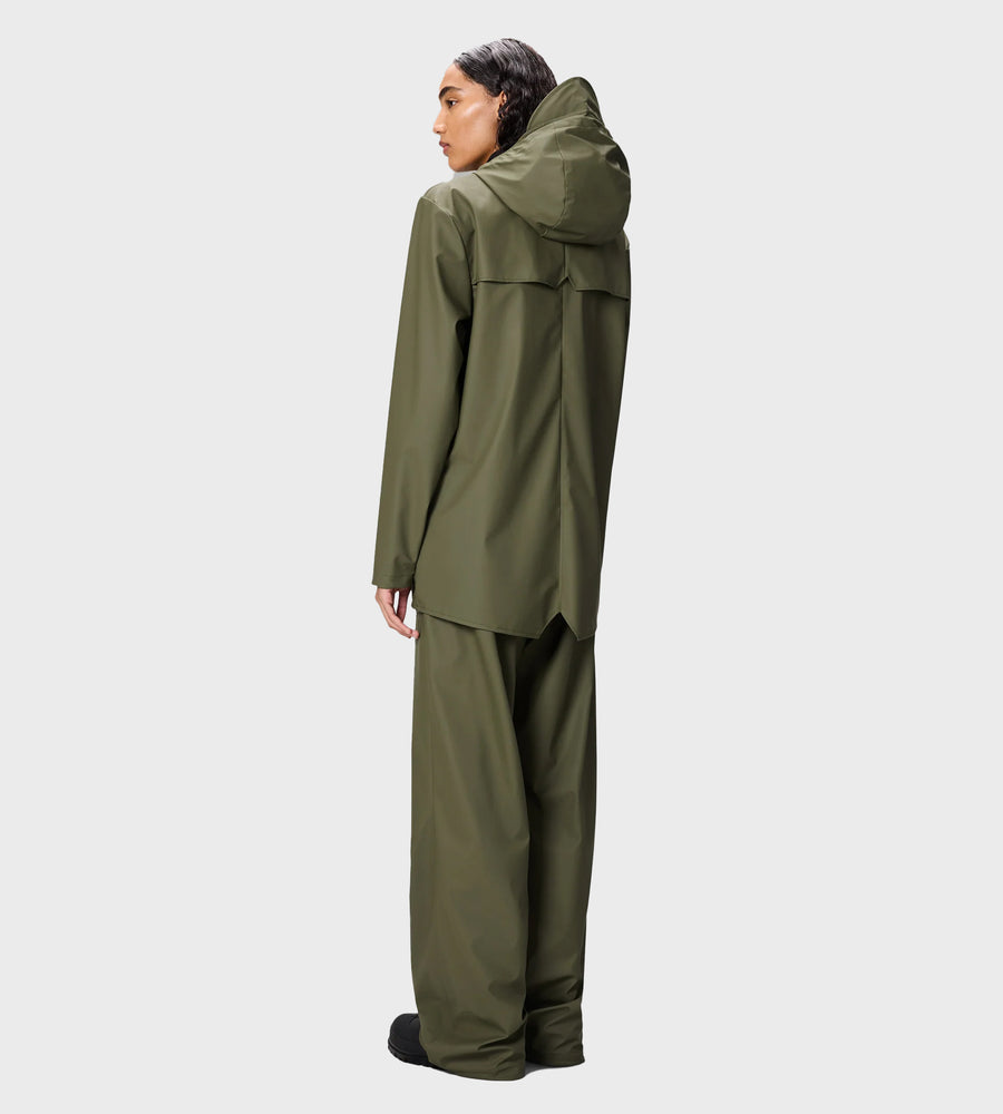 Person wearing a green raincoat and pants on a white background