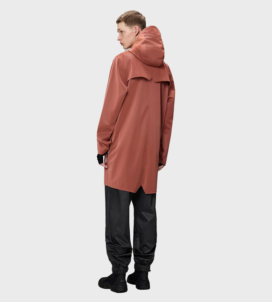 Person wearing a long, hooded brown coat on a white background