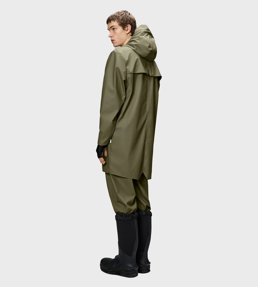 Person wearing a green raincoat and pants with black boots on a white background