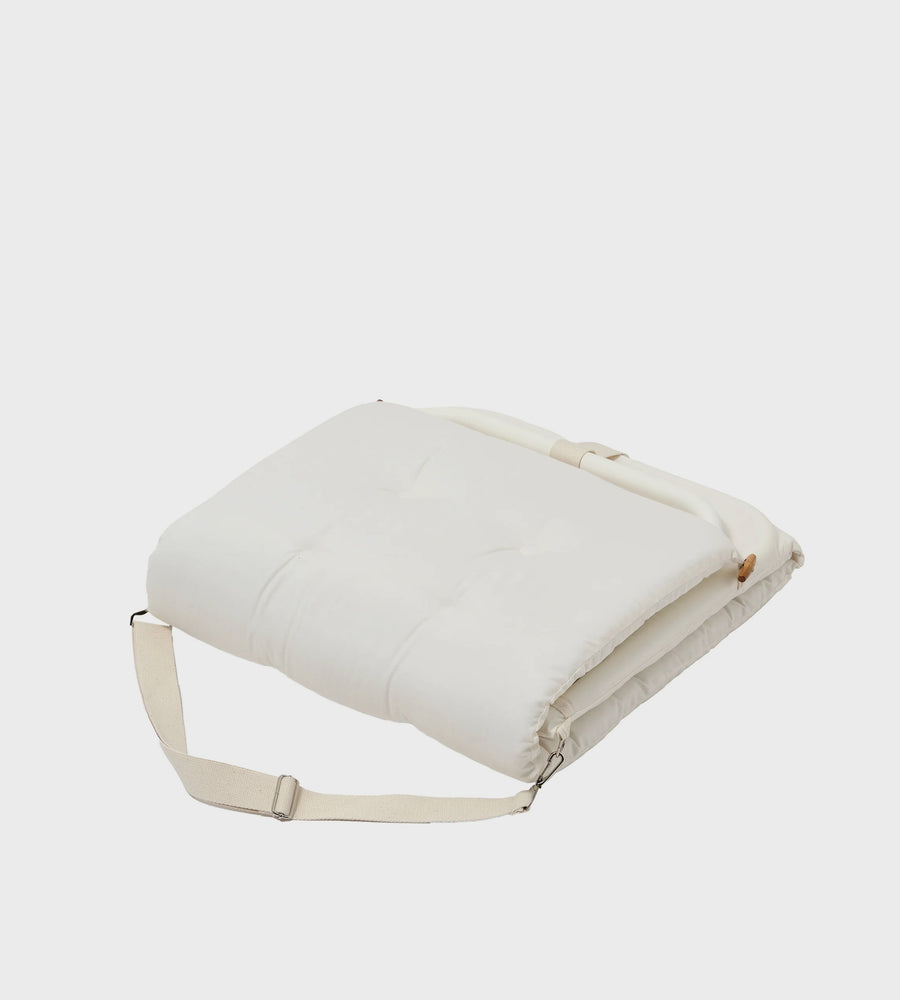 White cushion with a strap on a light gray background
