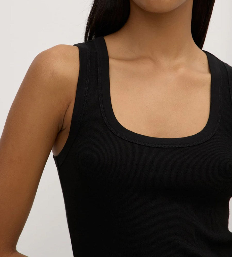 Black tank top worn by a person on a plain background