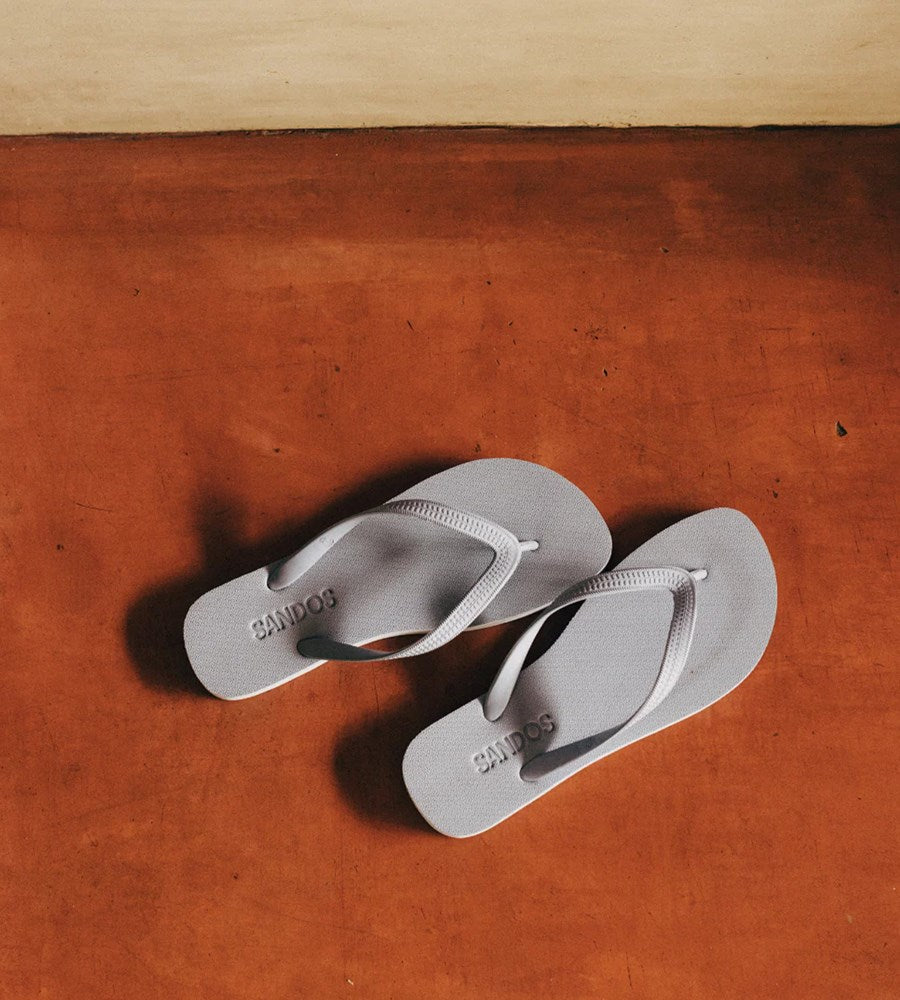 Pair of gray sandals on a wooden surface