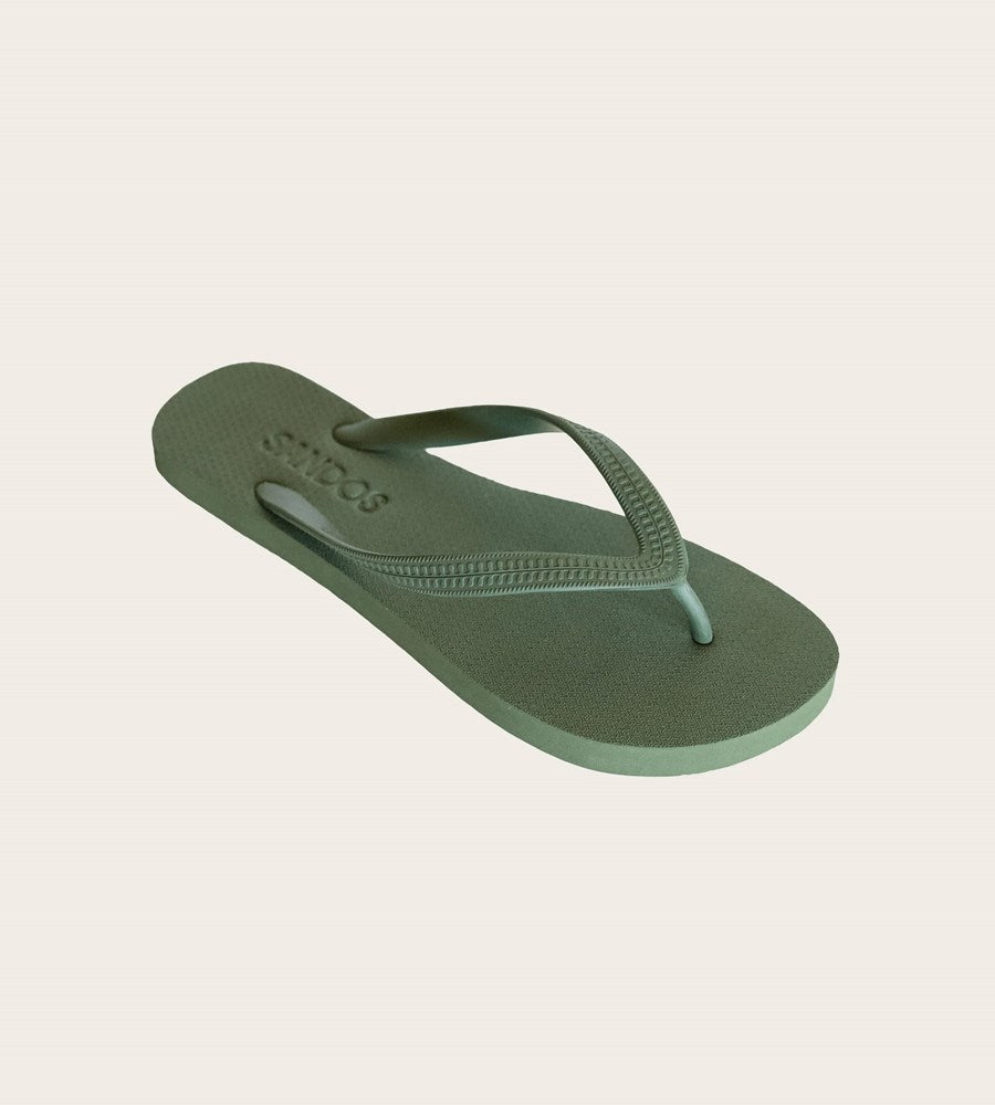 Green flip-flop sandal on a light beige background