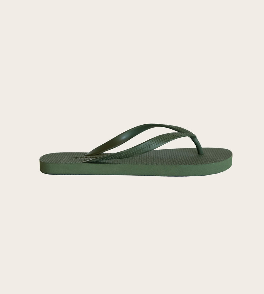 Green flip-flop sandal on a light beige background