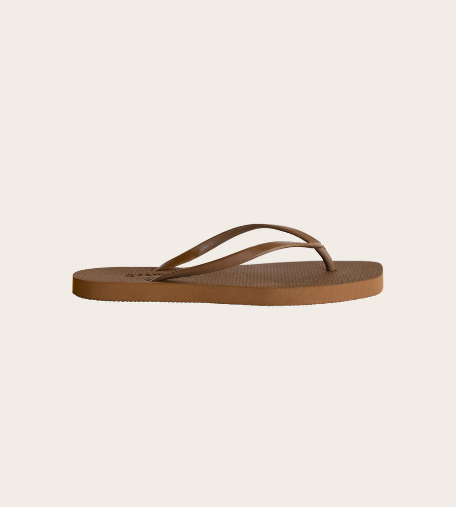 Brown flip-flop sandal on a beige background