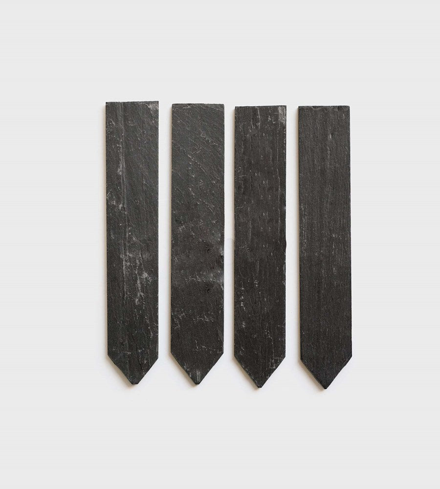 Four black wooden stakes on a white background