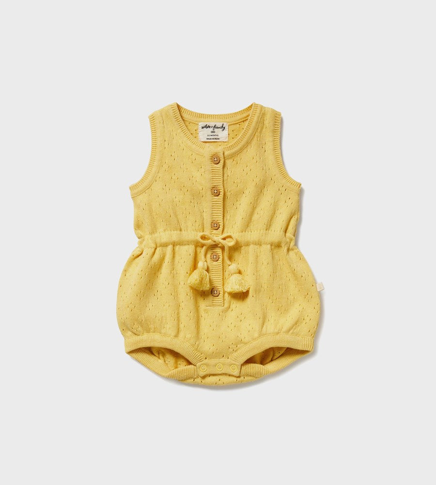 Yellow baby romper with buttons and pom-poms on a white background