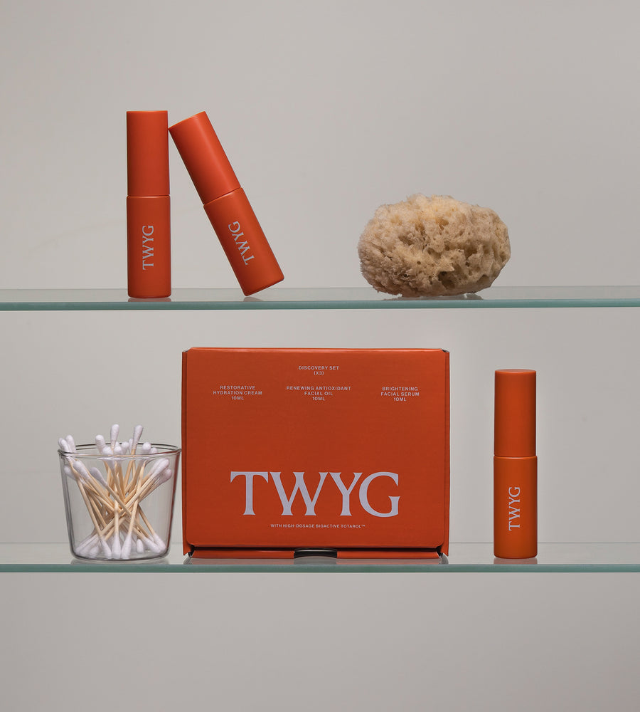 TWYG lip products on a glass shelf with a neutral background