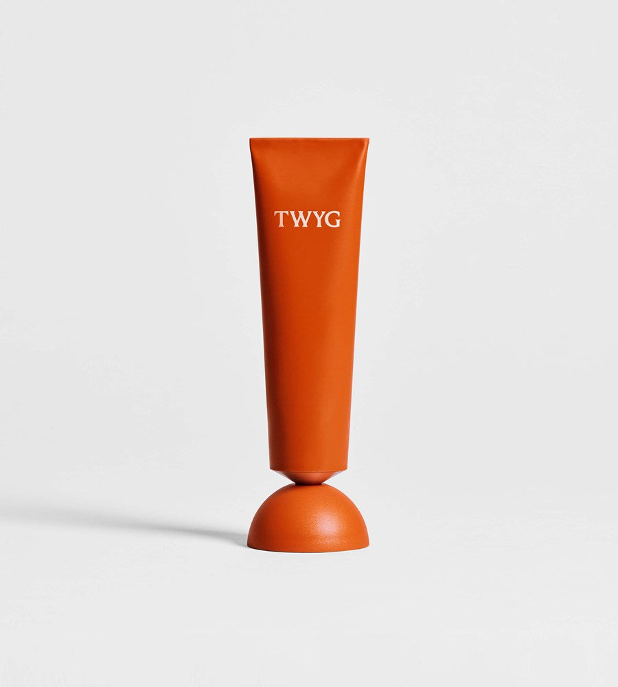 Orange cylindrical product with 'TWYG' branding on a light gray background
