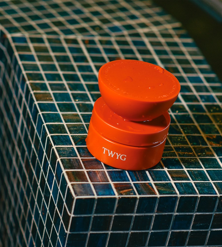 orange container with 'TWYG' branding on a blue tiled surface
